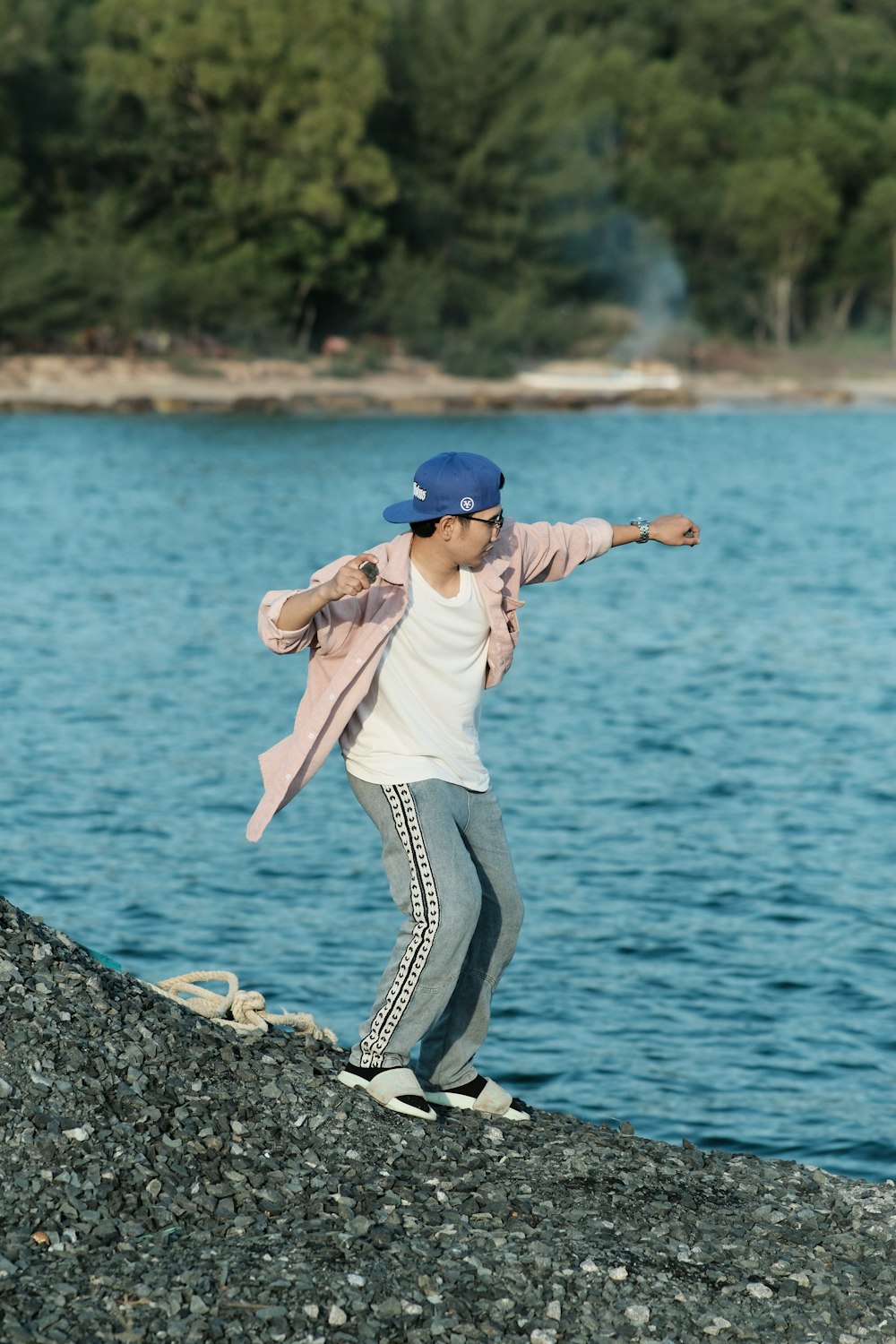 a person standing on a rock near a body of water