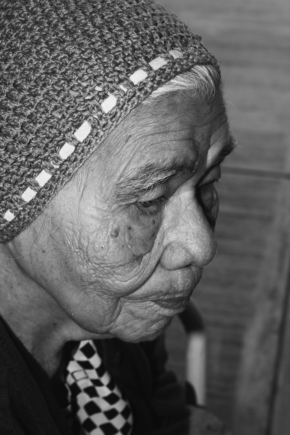 an old woman wearing a knitted hat and a tie
