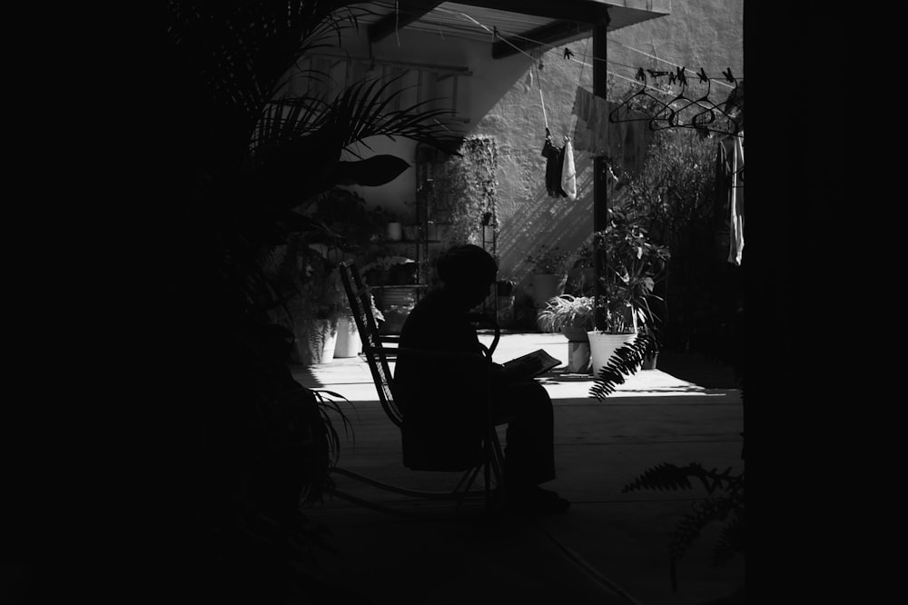 a black and white photo of a person sitting in a chair