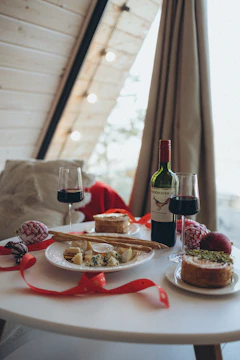 a table topped with plates of food and a bottle of wine