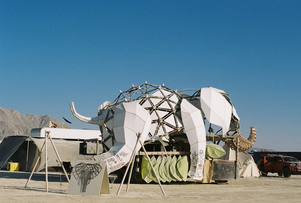 a large elephant sculpture sitting in the middle of a desert