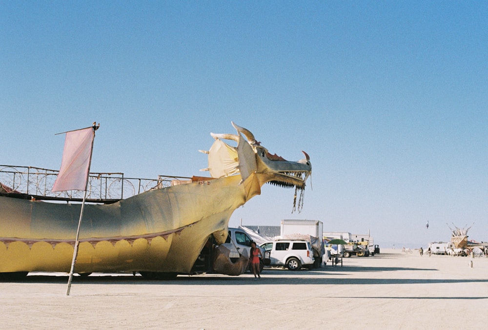 a large boat shaped like a dragon on a beach