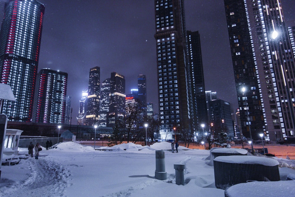 Eine verschneite Stadt bei Nacht mit Wolkenkratzern im Hintergrund