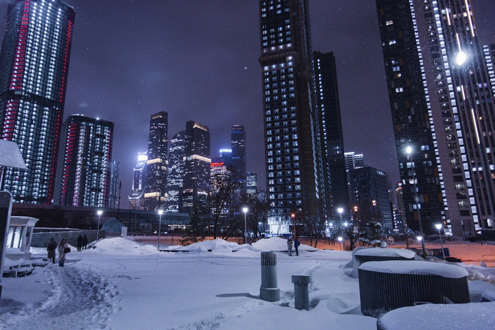 a snowy city at night with skyscrapers in the background