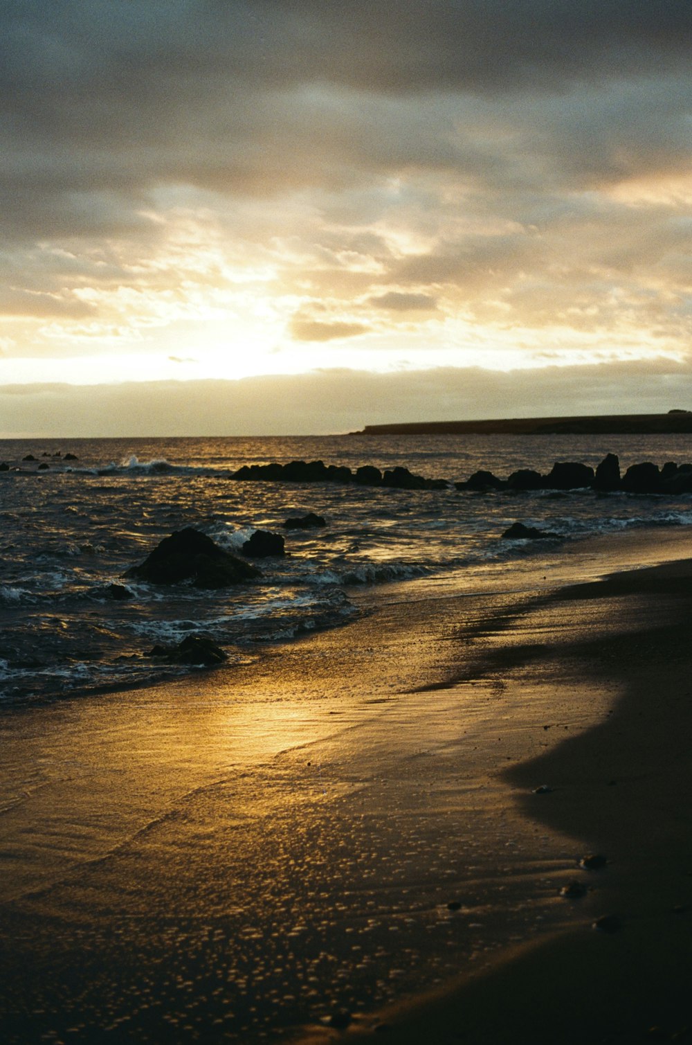 a person walking on the beach at sunset