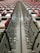 A close-up view down the center of a series of industrial electrical or communication panels, featuring rows of red tabs on each panel. Labeling and numbers are present on the metal surface, indicating organization and connectivity with screws and bolts as part of the assembly.