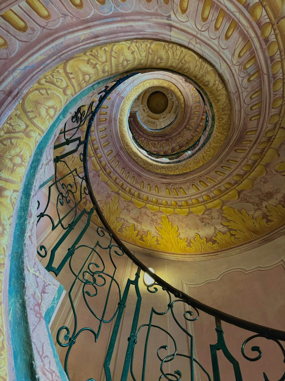a spiral staircase in a building with a painting on it