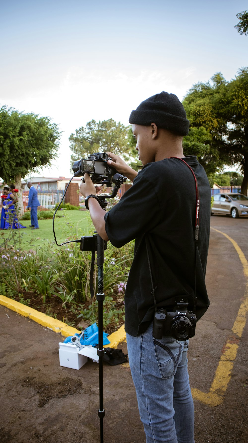 a man holding a camera up to a tripod