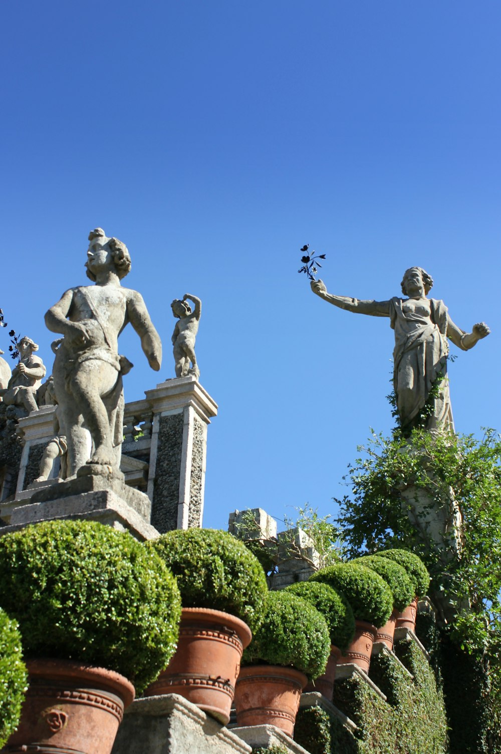 statues on top of a building with a blue sky in the background