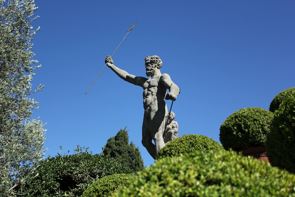 a statue of a man holding a stick