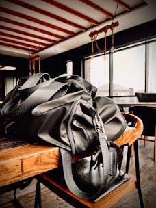A stylish duffel bag packed and ready beside a cozy café table.