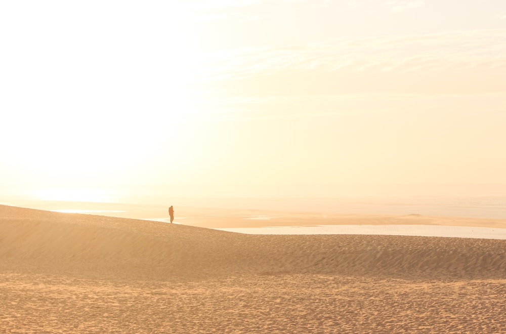 a person standing on top of a sandy hill