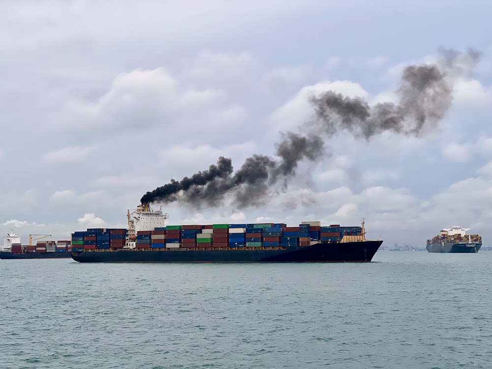 a large cargo ship with a lot of smoke coming out of it
