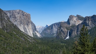 A serene view of the Ourika Valley waterfalls framed by lush greenery under a clear blue sky.