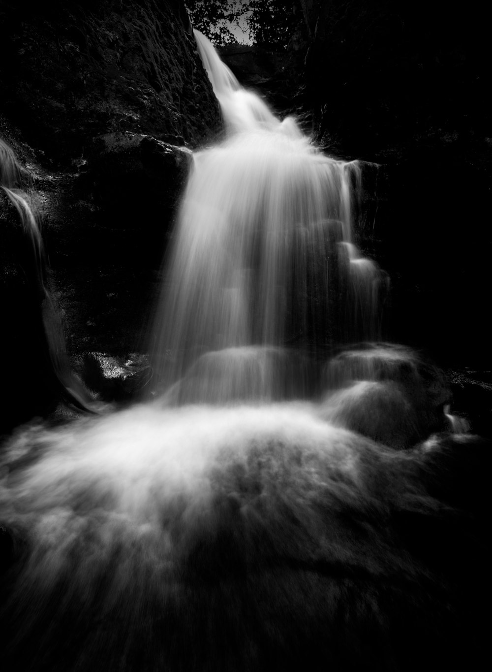 a black and white photo of a waterfall