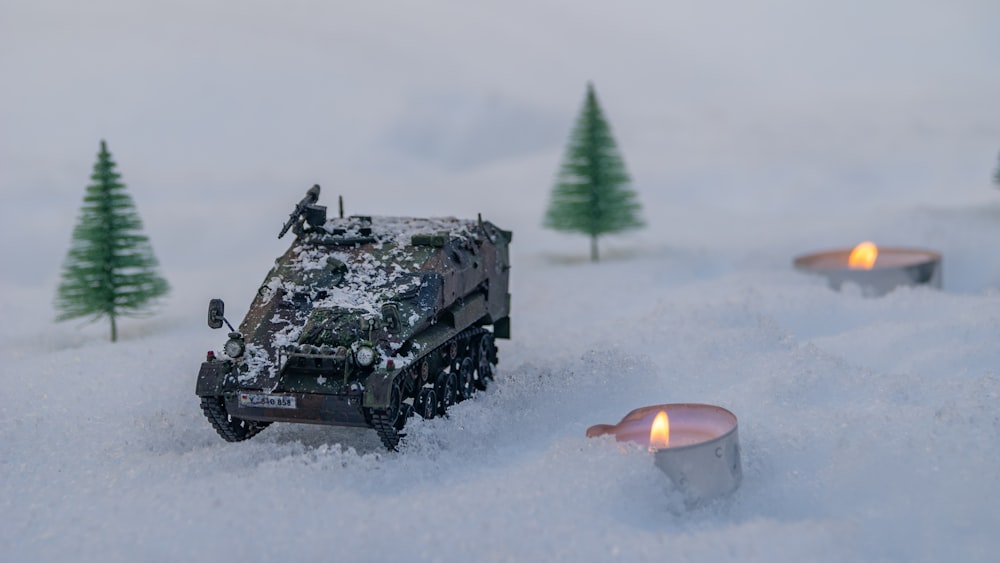 a toy army vehicle driving through the snow