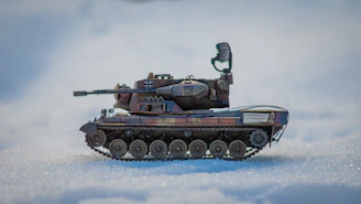 A sleek, high-tech military tank rolling through a digital battlefield with camouflage patterns blending into the background.