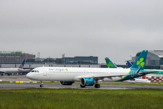 A sleek black taxi waiting outside Dublin Airport terminal under a cloudy sky.