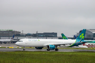 A sleek black taxi waiting outside Dublin Airport terminal under a cloudy sky.