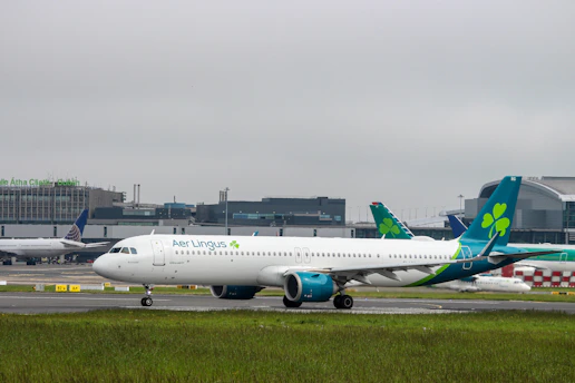 A sleek black taxi waiting outside Dublin Airport terminal with a clear sky.