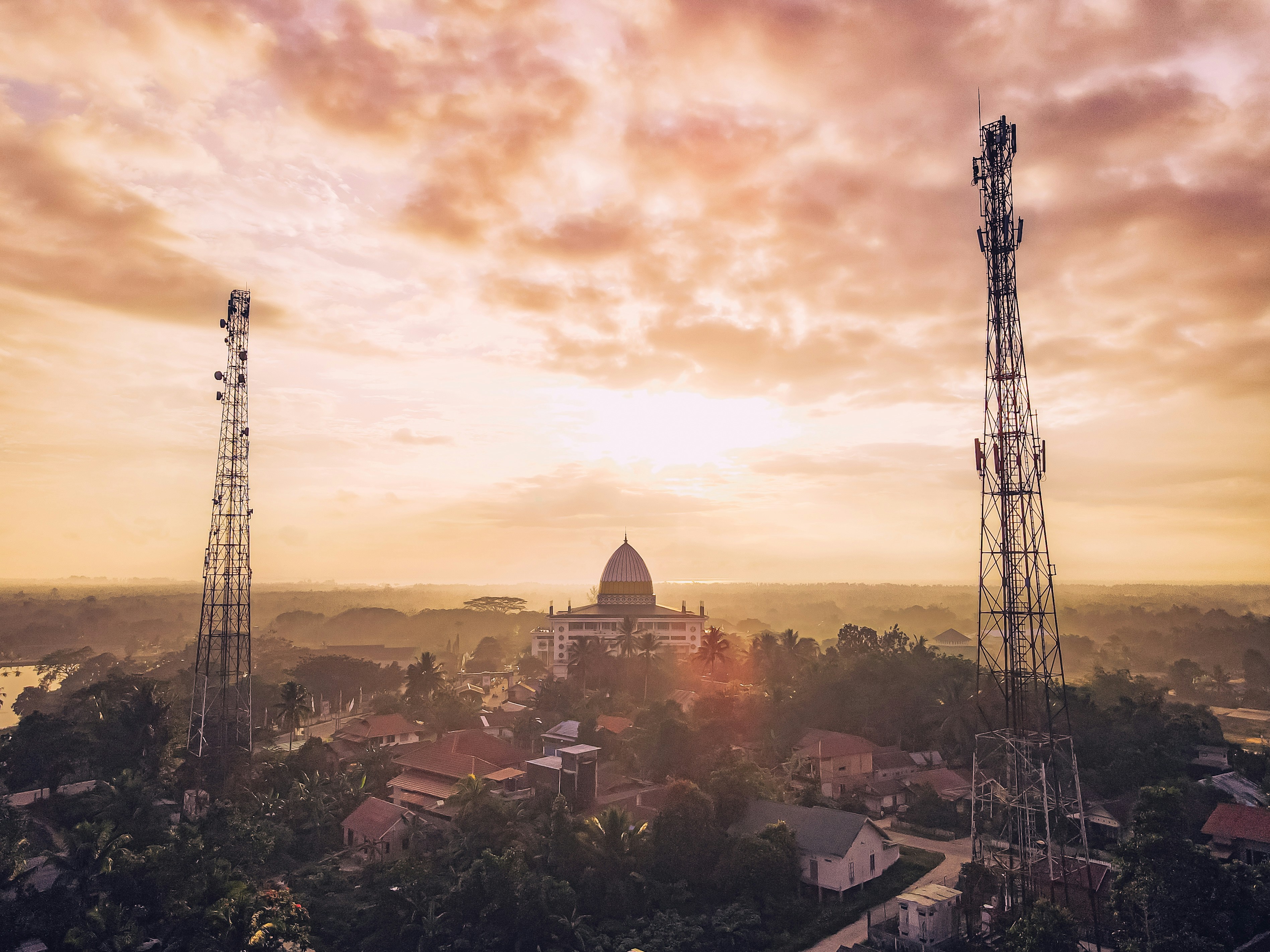 Una vista al tramonto di una città con ripetitori cellulari