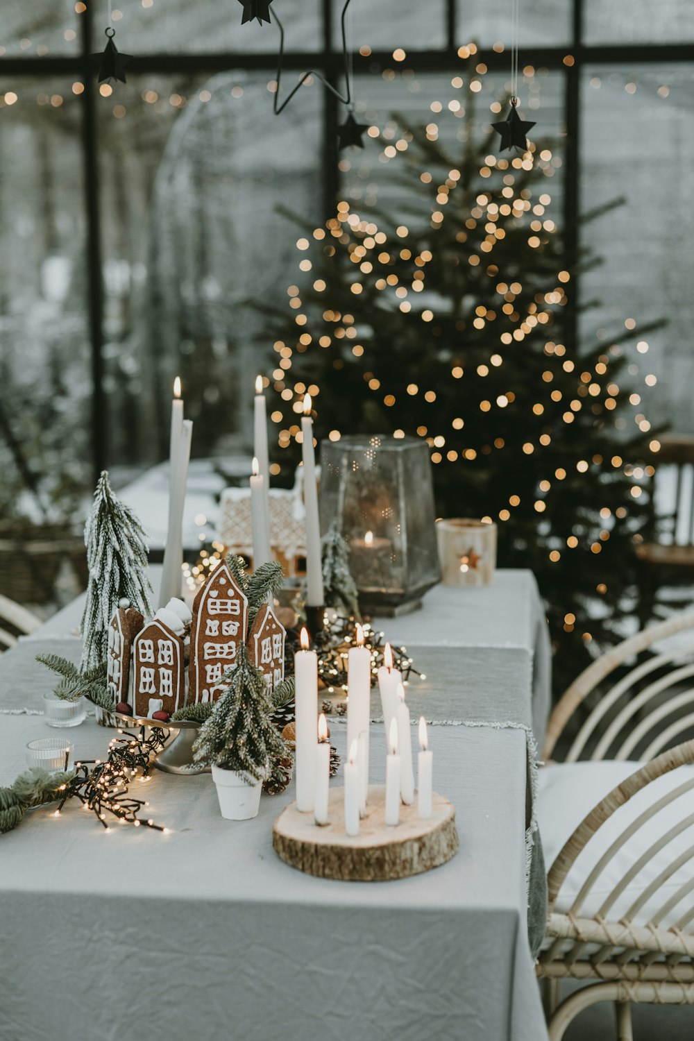 a table topped with a lit candle next to a christmas tree