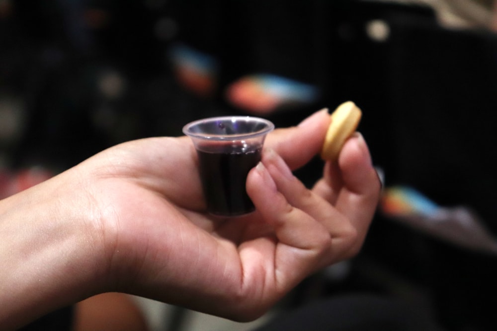 a person holding a small cup with something in it