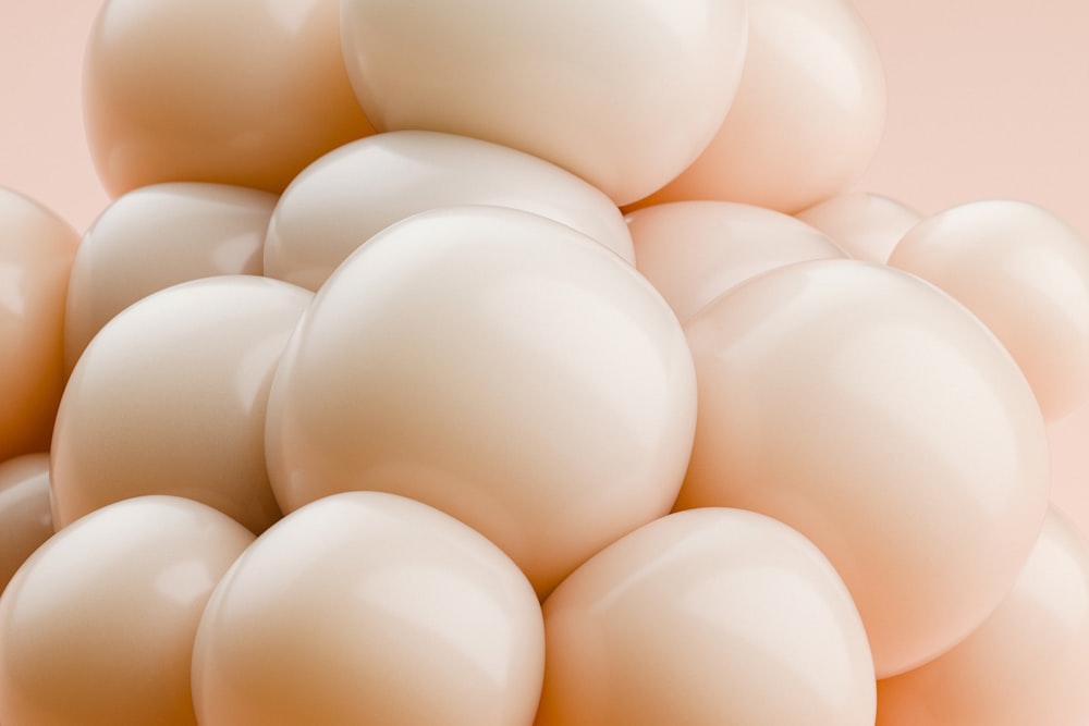 a pile of white balloons on a pink background