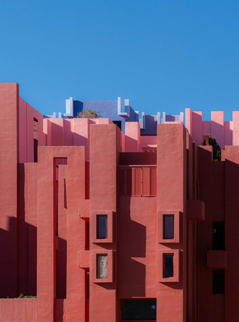 Ein rotes Gebäude mit vielen Fenstern und einem Himmelshintergrund