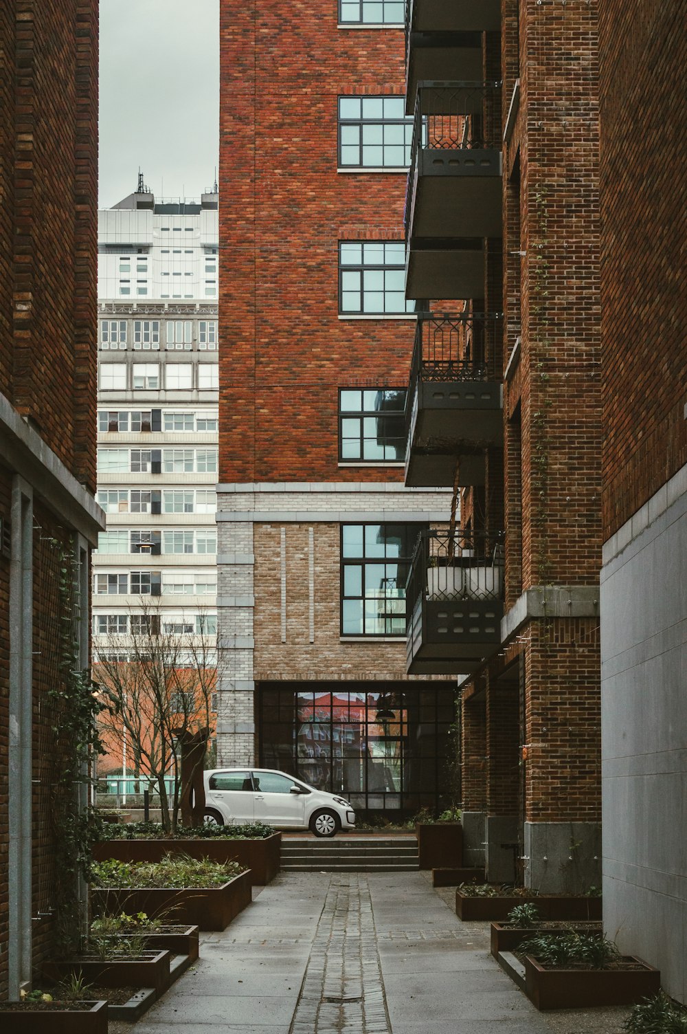 a car is parked in a courtyard between two buildings