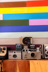 Colorful display of vintage cameras arranged on a bright table.