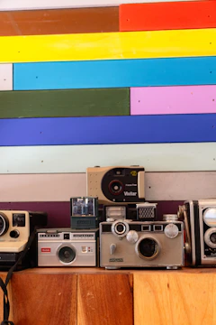 Colorful display of vintage cameras arranged on a bright table.