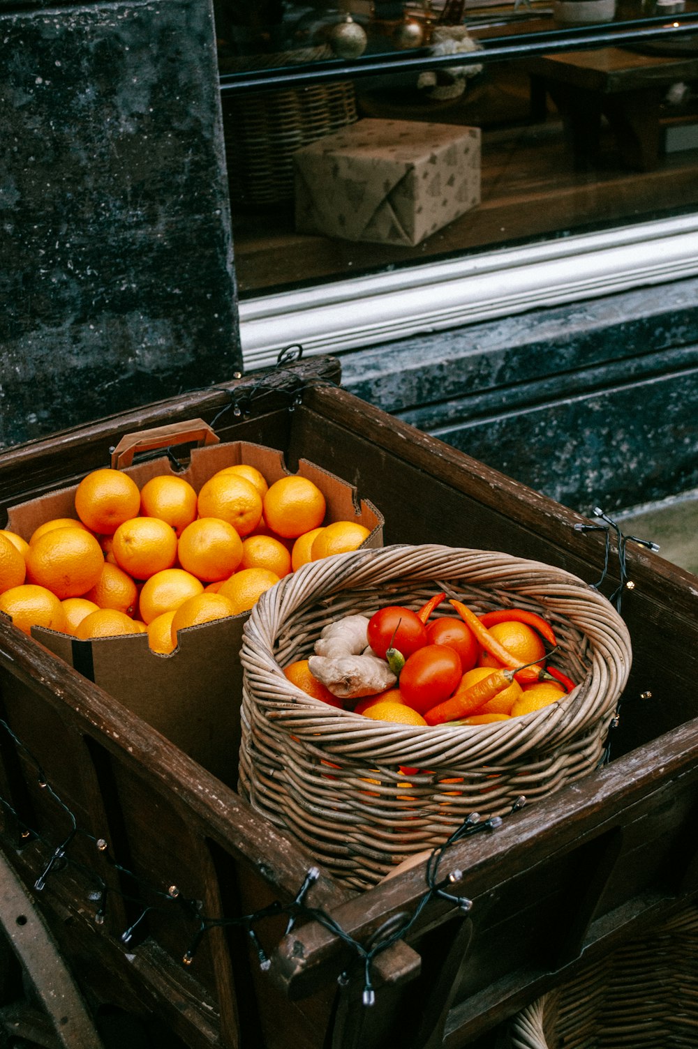 a basket of oranges and a basket of tomatoes