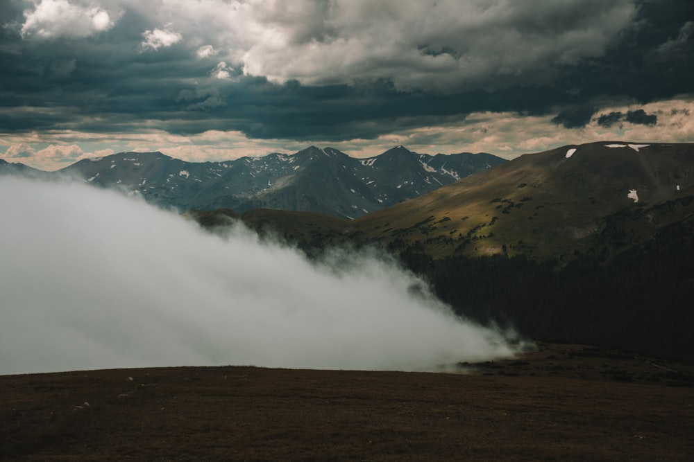 a view of a mountain range covered in clouds