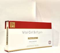A box labeled 'Vital Cell Softgels' features a red and gold design. It is branded with 'Bh mod' and described as a dietary supplement containing 30 softgels of premium extract.