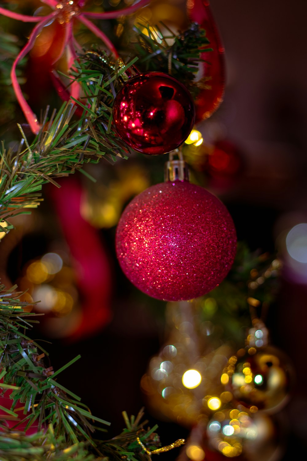 a red ornament hanging from a christmas tree