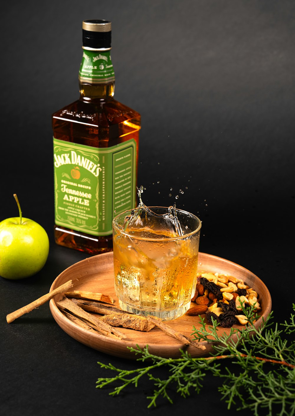 a bottle of jack daniels next to a glass of apple cider
