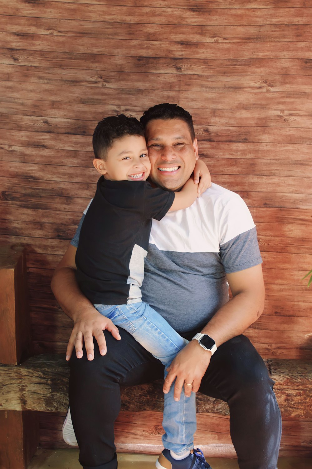 a man sitting on a bench holding a little boy