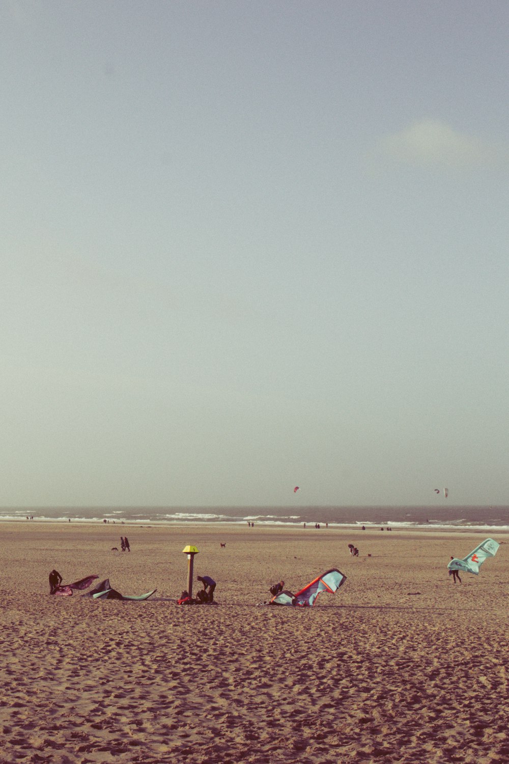 a group of people standing on top of a sandy beach