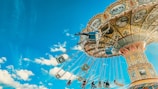 Children laughing on a colorful carousel under bright Saudi Arabian skies.
