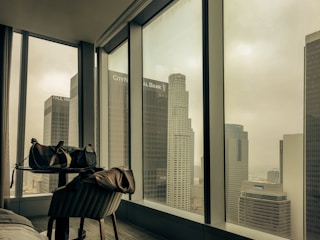 A cozy, modern apartment with a view of Sydney's skyline at sunset, welcoming business travelers.