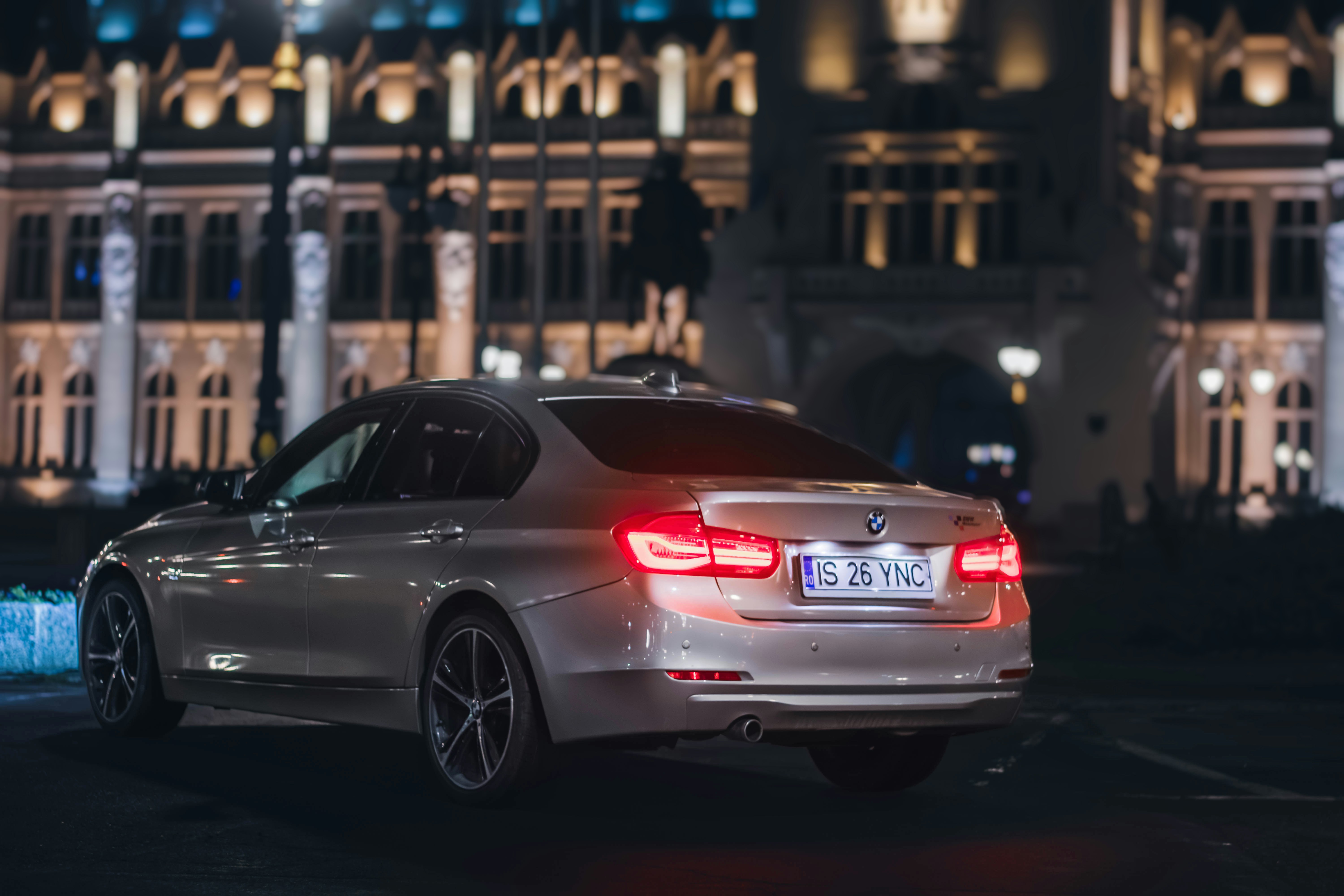 a silver car parked in front of a building at night
