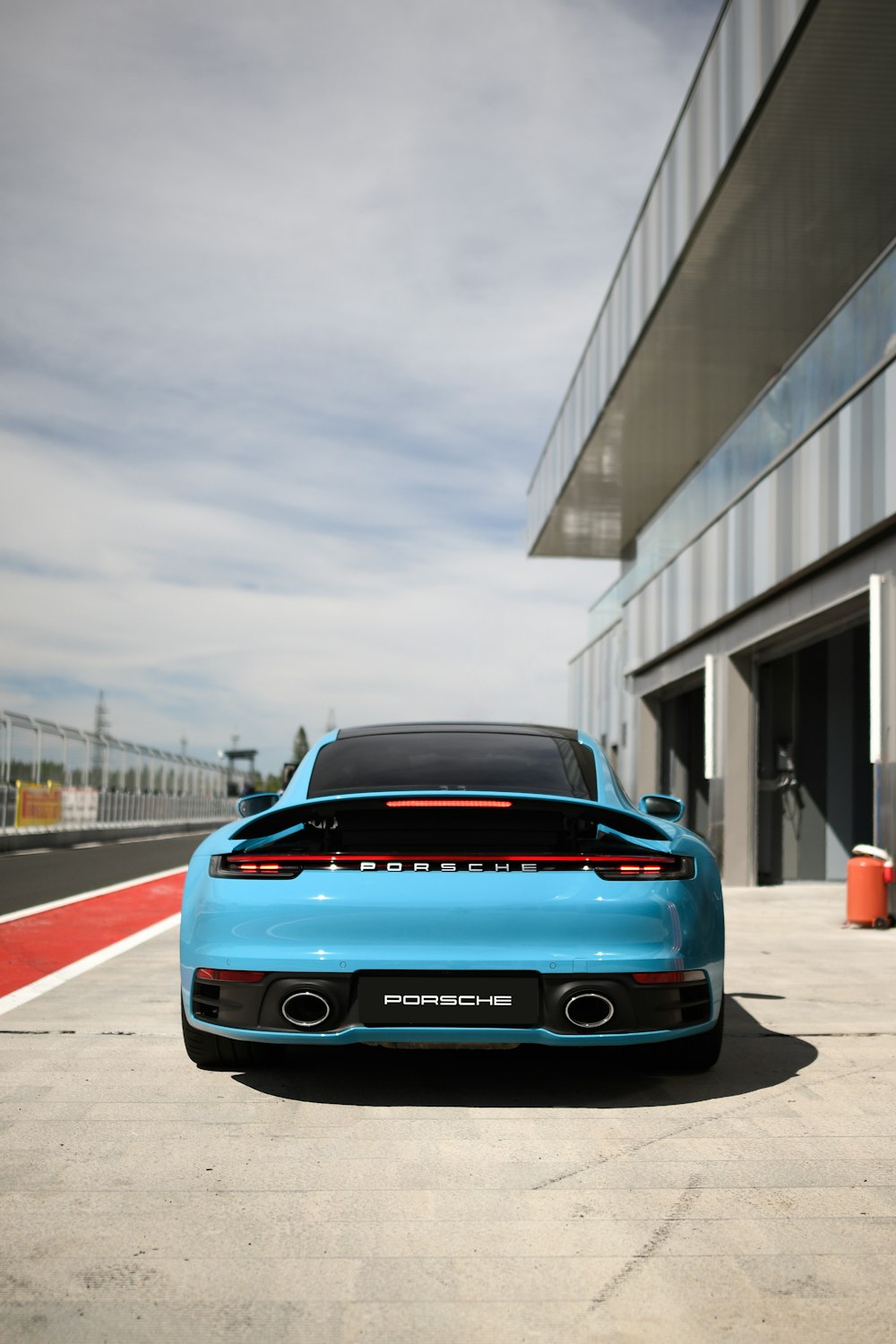 a blue sports car parked in front of a building