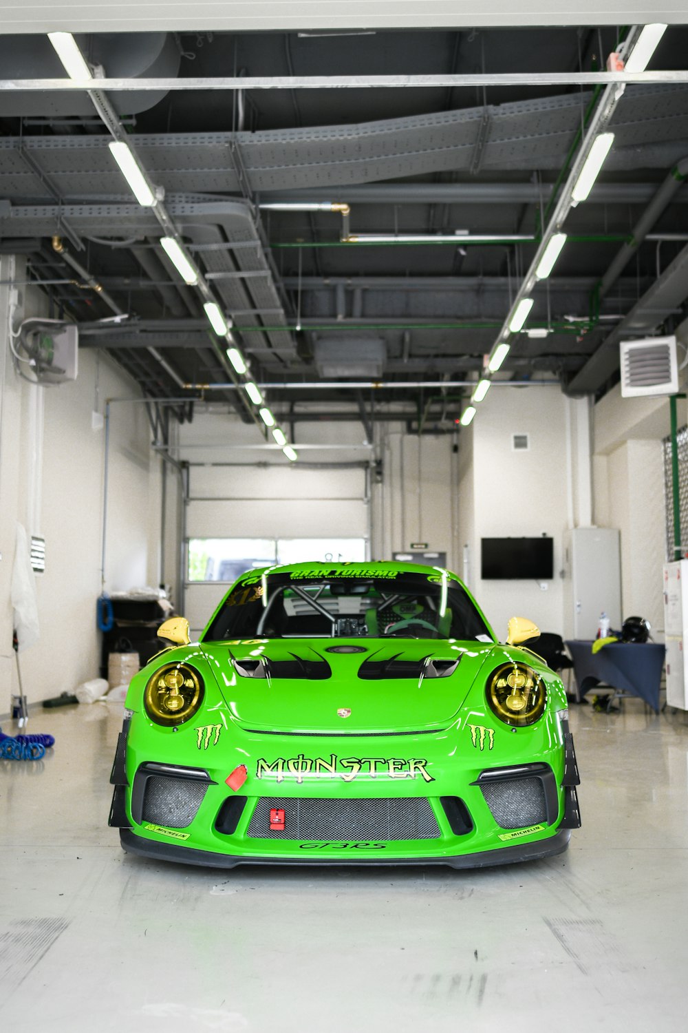 a green sports car parked in a garage