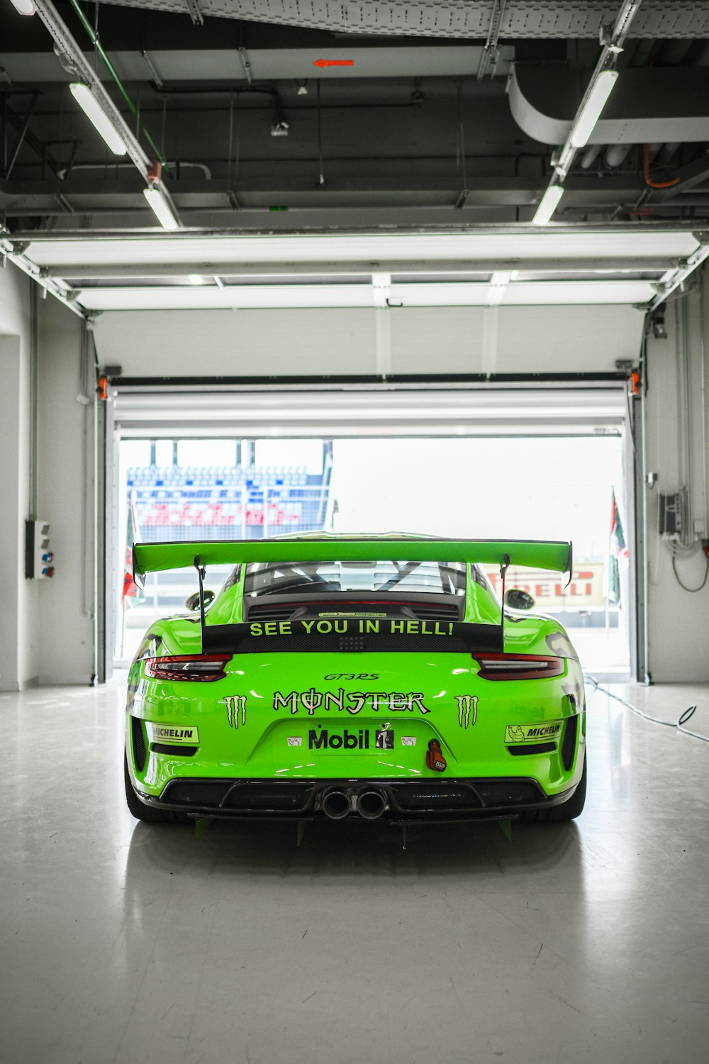 a green sports car parked in a garage