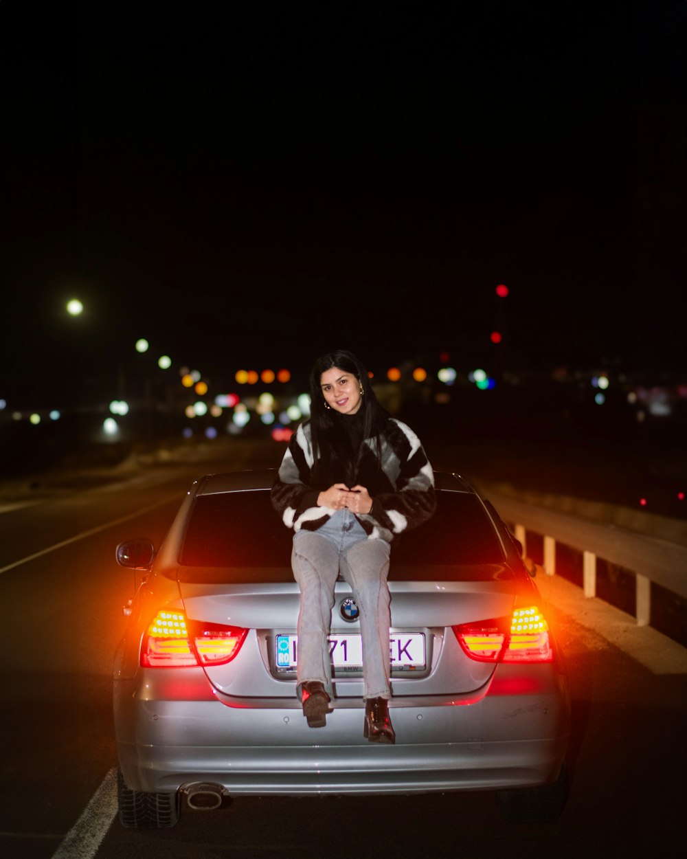 a woman sitting on the hood of a car