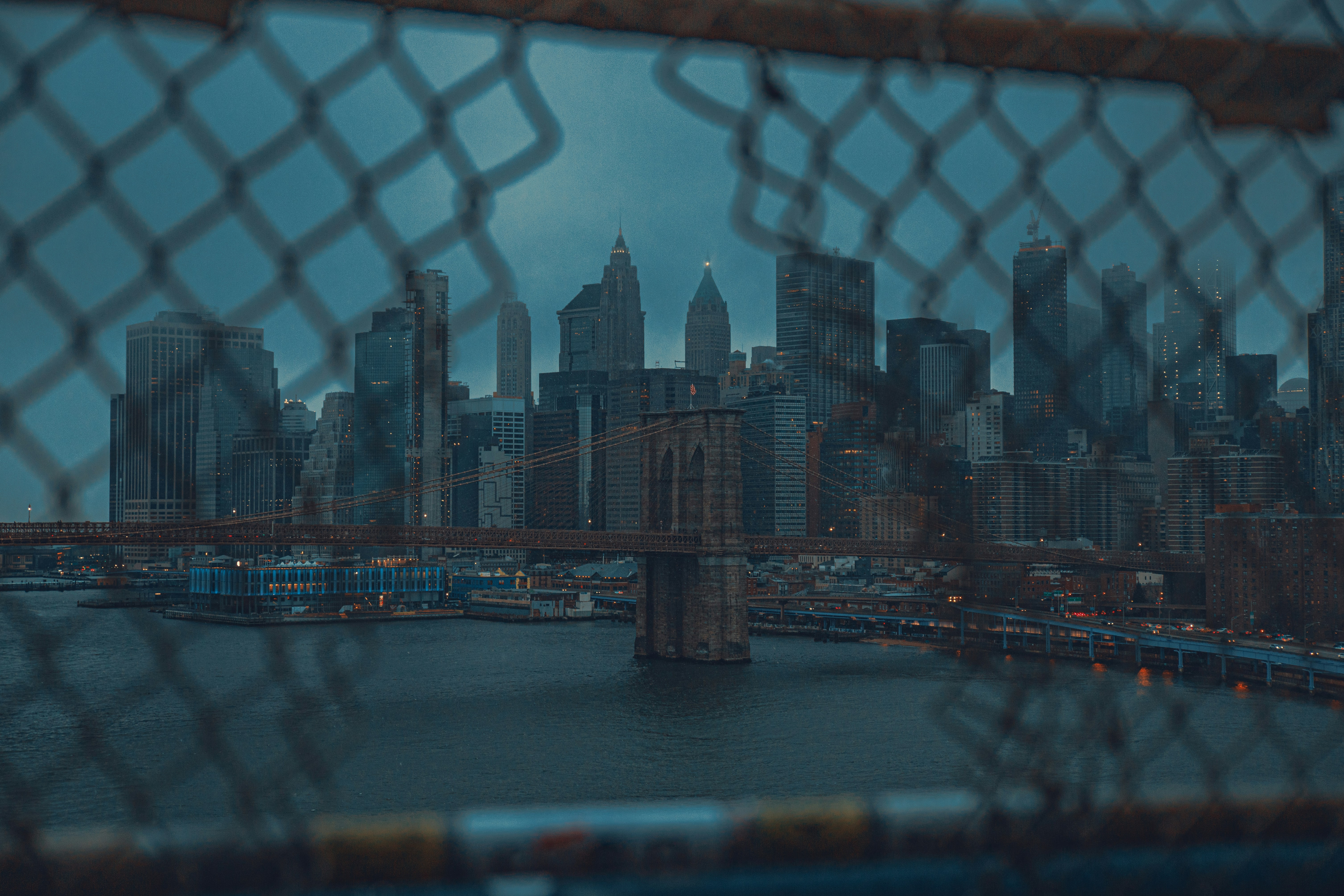 Blick auf eine Stadt durch einen Maschendrahtzaun