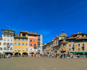 A vibrant city square bustling with people and colorful buildings