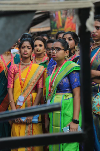 A group of women in vibrant traditional Indian attire engaged in skill-building workshop outdoors.