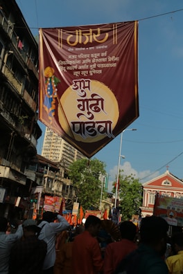 Rajesh More addressing a lively crowd at a Shivsena rally, with orange banners waving.